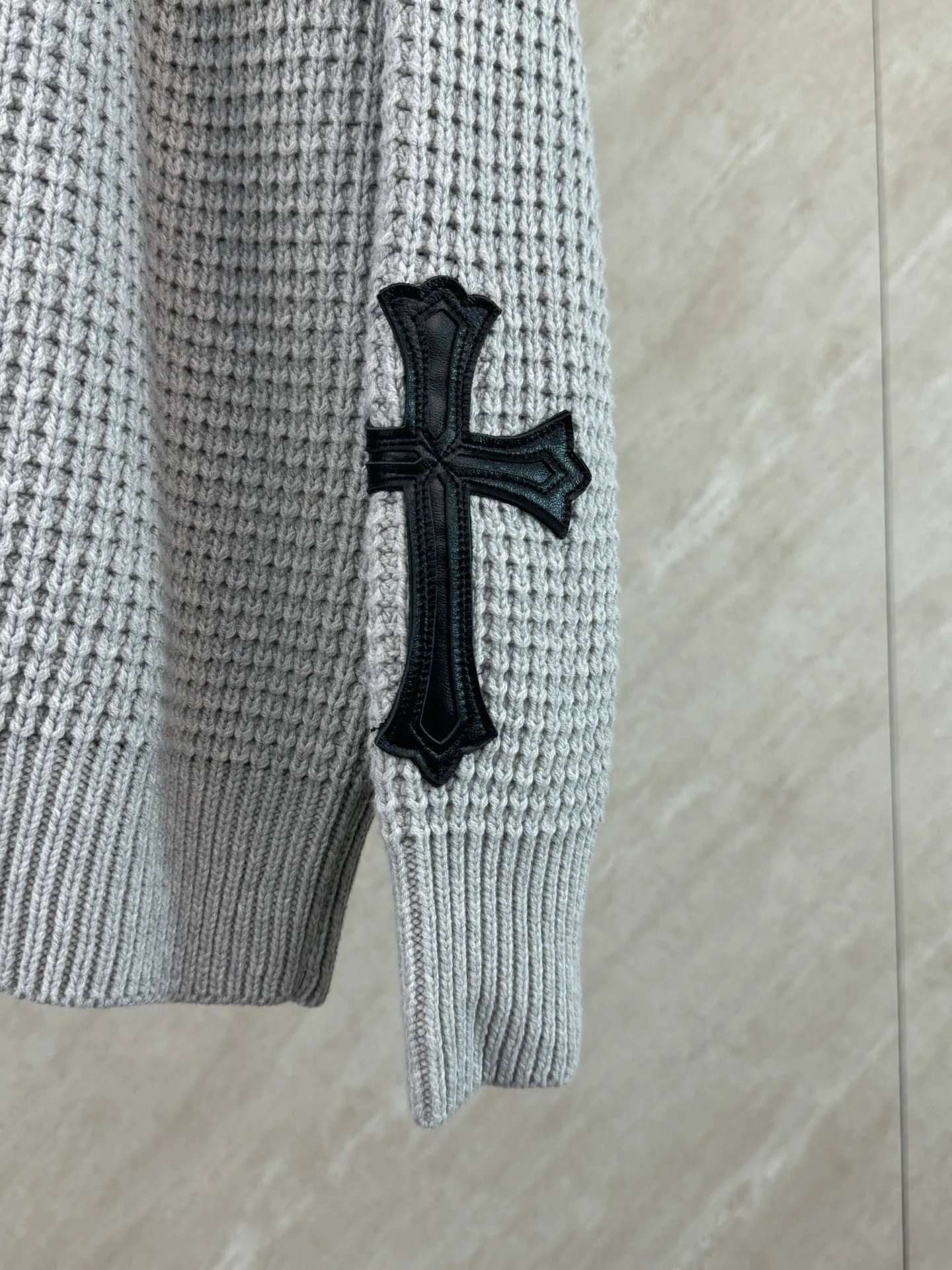 P570 Chrome Hearts cashmere waffle sweater size s m l The main body fabric is made of custom-woven and dyed cashmere and mulberry silk blended yarn. The whole dress takes nearly 200 minutes. The Chrome Hearts cross leather on both sides of the sleeves is genuine sheepskin. The hardware and cross sheepskin are all hand-sewn. The labor cost is extremely high. The back hardware accessories are molded and made to order. They are aged and oxidized.